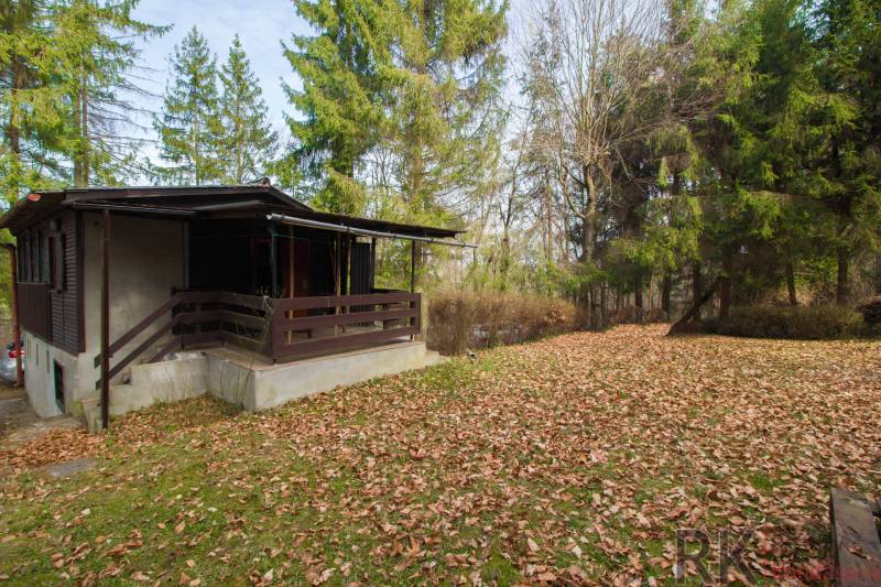 Eine Hütte in der Natur auf Erholungsgrundstücken in Holčíkovce, umgeben von Nadelbäumen.