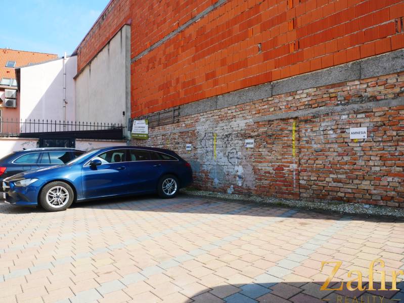 Parkplatz bei einem Backsteingebäude in den Gastronomiebereichen von Trnava.