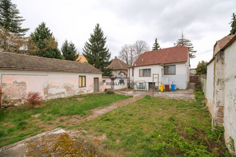 Der Garten und die Gebäude des Einfamilienhauses in der Zelenečská Straße in Trnava, umgeben von Bäumen.