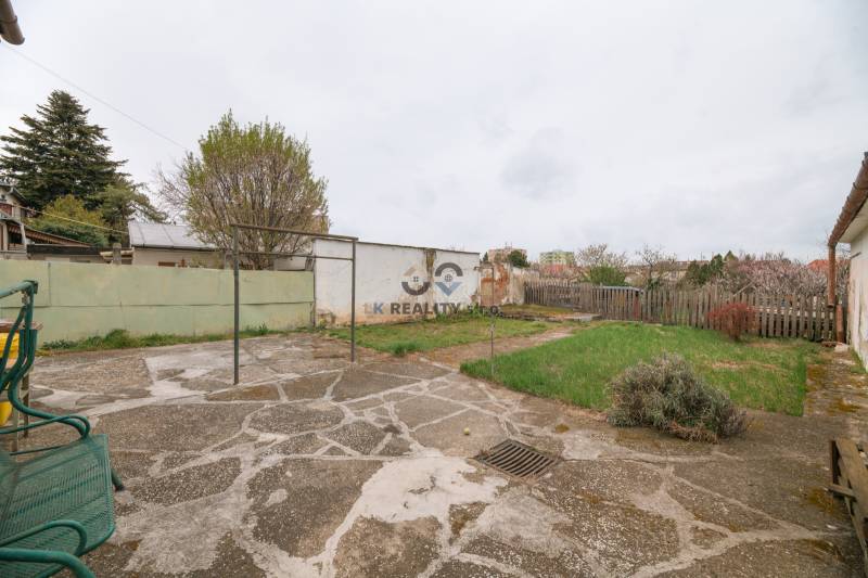 Garten bei einem Einfamilienhaus in der Zelenečská-Straße in Trnava mit Rasen und Pflastersteinen.