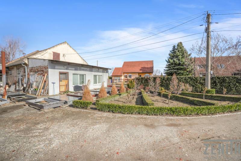 Gewerberäume in Okoč mit Gartenanlage, umgeben von Bäumen und Sträuchern.