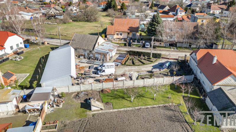 Geschäftsräume in Okoč mit umliegenden Häusern in einer ruhigen ländlichen Gegend.