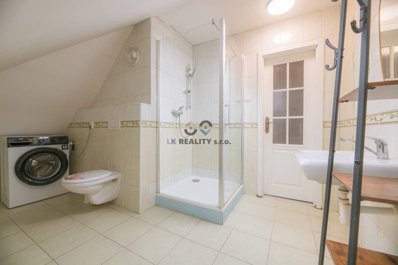 Badezimmer in einer 2-Zimmer-Wohnung mit Waschmaschine, Toilette und Dusche.