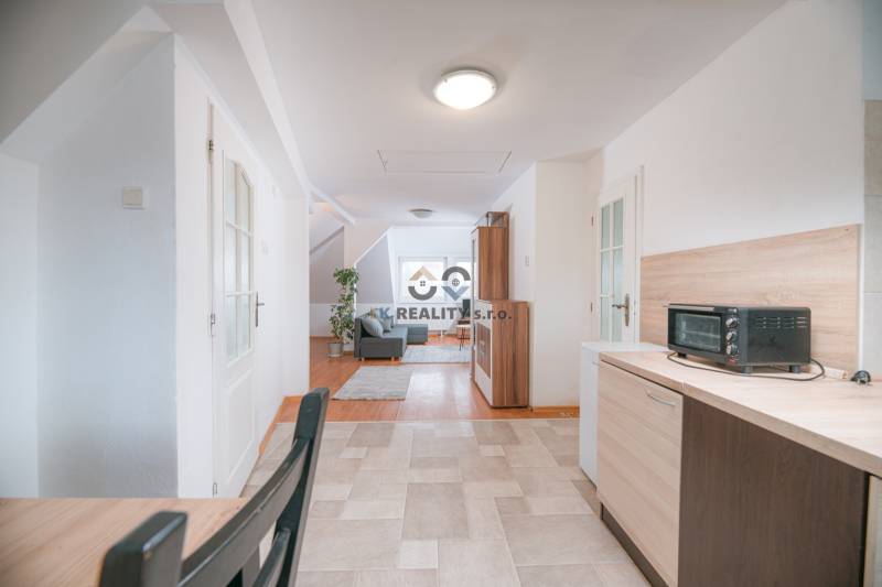 Helle Küche, verbunden mit dem Wohnzimmer und einem Holzboden in einer 2-Zimmer-Wohnung.