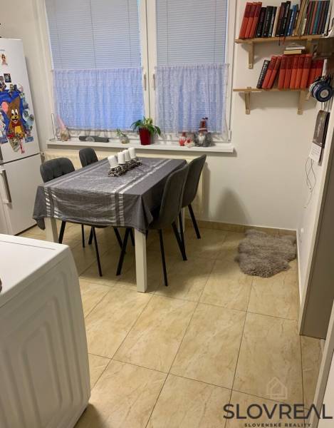 Essbereich in einer Zweizimmerwohnung mit einem weißen Tisch und grauen Stühlen.