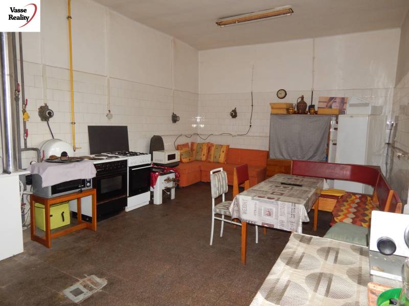 Innenraum von Gastronomiebereichen mit ausgestatteter Küche und Sofa, Boden mit Holzdekor.