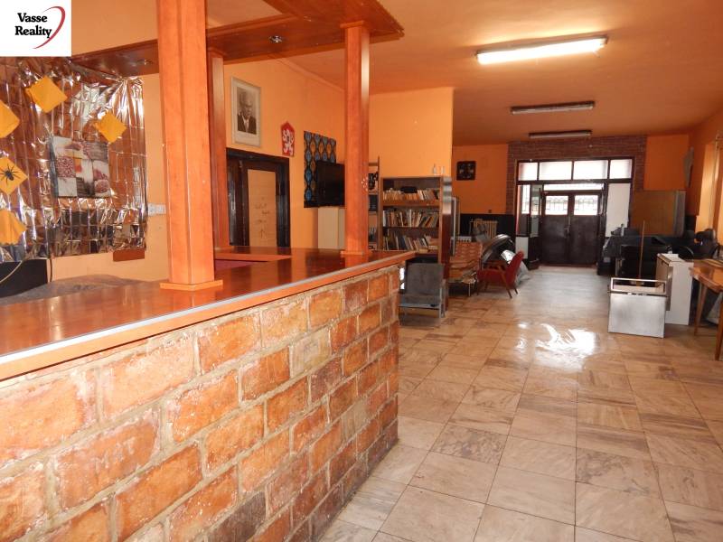 Interieur eines Gastronomiebereichs mit Tisch und Bücherregalen.