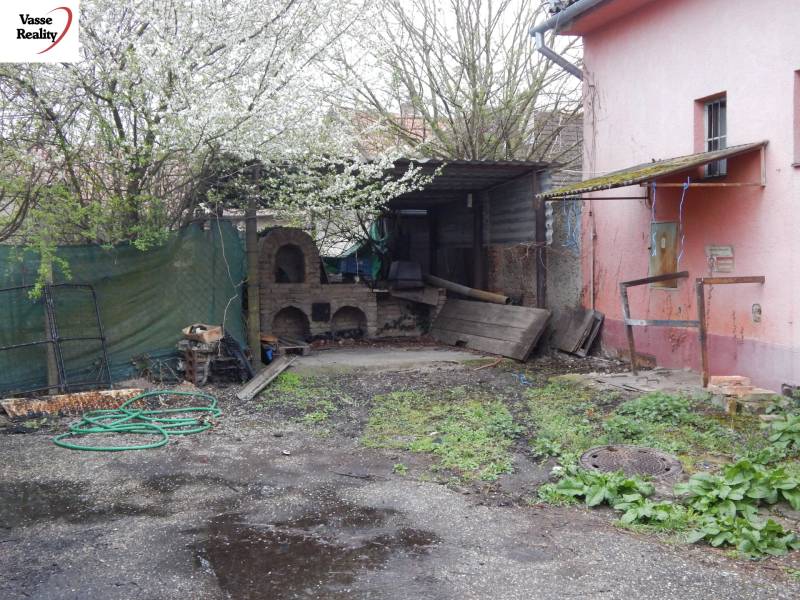 Außenbereich in den Gastronomieräumen in Búč mit einem alten Ofen und Frühlingsvegetation.