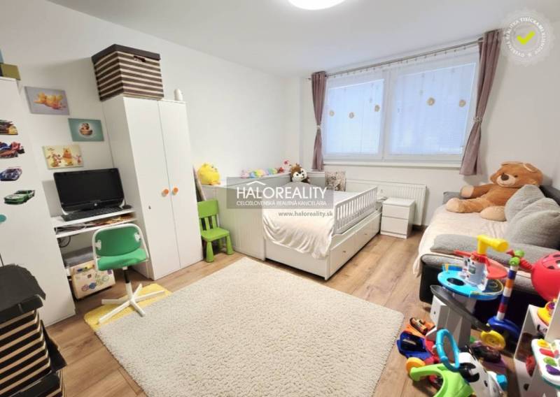 Kinderzimmer mit weißen Möbeln, Teppich und Boden mit Holzdekor in einer 3-Zimmer-Wohnung.