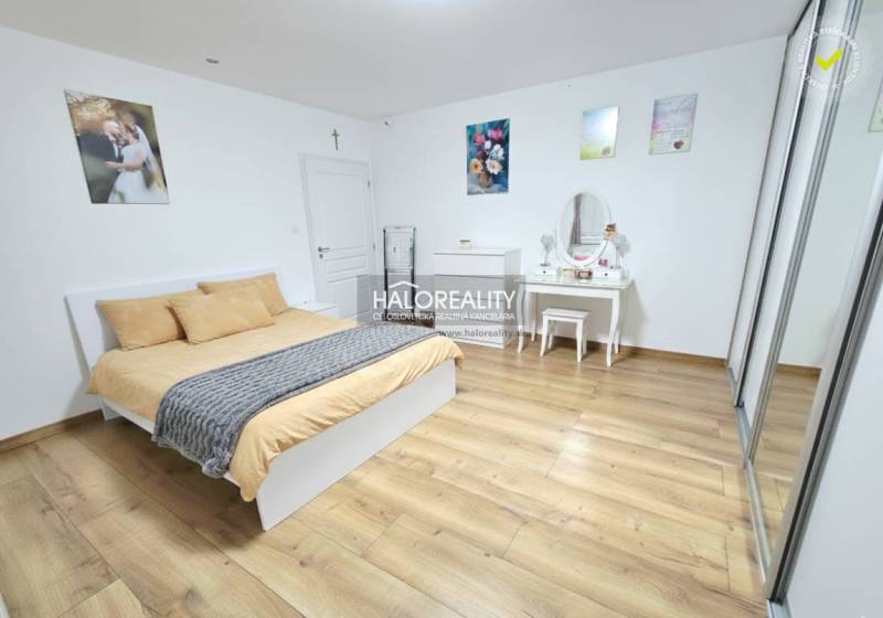 Schlafzimmer mit Bett, Kleiderschrank und Holzboden in einer 3-Zimmer-Wohnung.