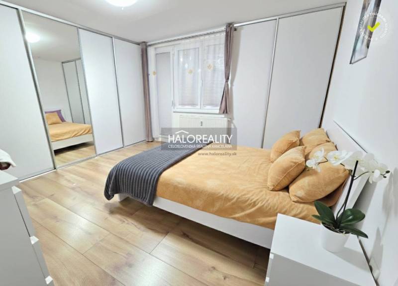 Helles Schlafzimmer in einer 3-Zimmer-Wohnung mit großem Einbauschrank und Boden in Holzoptik.