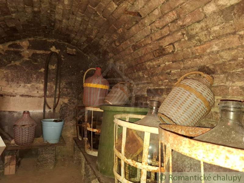 Weinkeller in der Hütte mit Steinen und Demijohns in Kamenín.