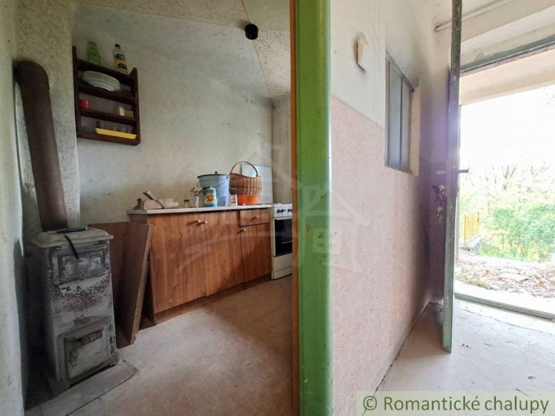 Innenraum einer Hütte mit einem alten Ofen und Möbeln auf einem Boden mit Holzdekor.