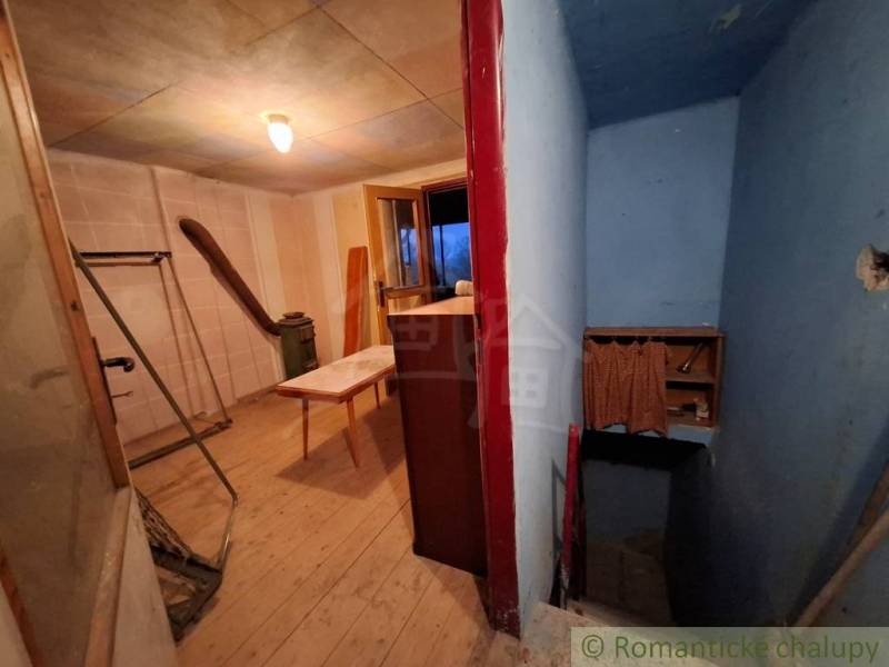 Innenraum einer Hütte mit Holzboden, Flur und Tisch.