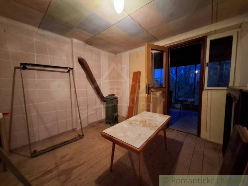 Innenraum einer Hütte mit Holzboden und alten Möbeln.