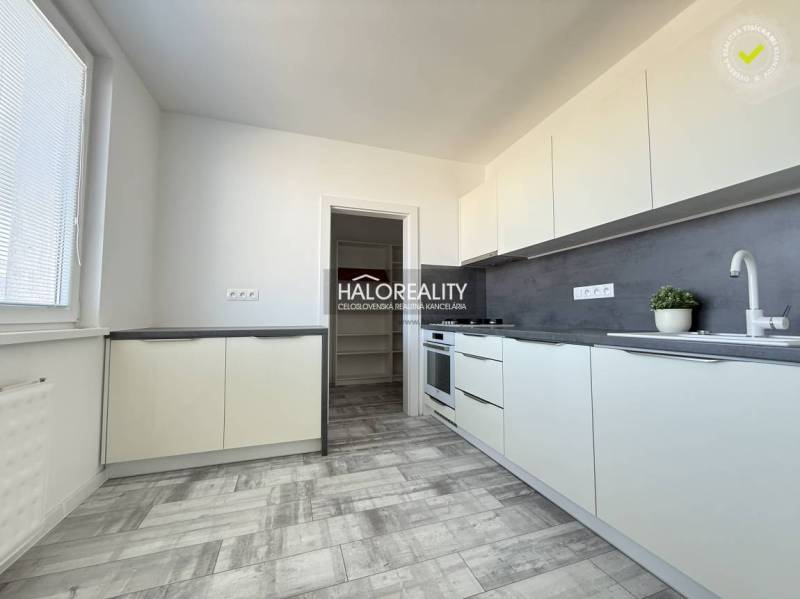 Küche in einer 2-Zimmer-Wohnung mit Holzboden und hellen Möbeln.