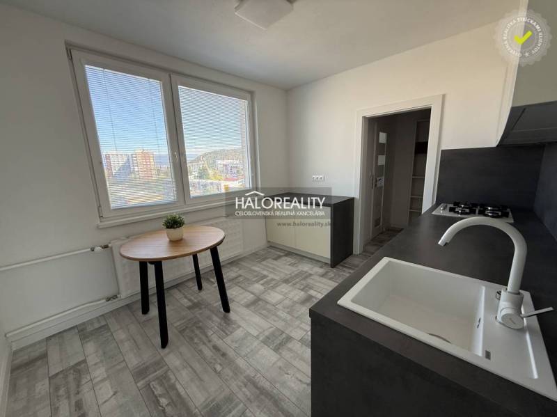 Küche in einer 2-Zimmer-Wohnung mit Aussicht, Holzboden, einfache Möbel.