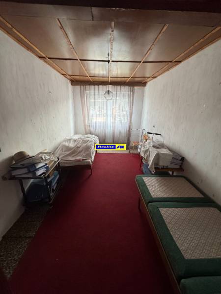 Ein Zimmer in einem Einfamilienhaus mit rotem Teppich und Betten auf beiden Seiten.