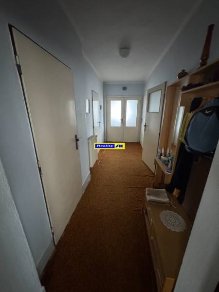 Der Flur in einem Einfamilienhaus mit braunem Teppich und weißen Türen.