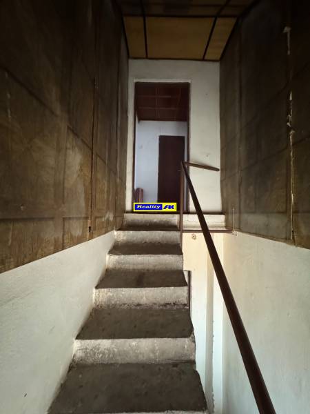 Eine Treppe in einem Einfamilienhaus mit einem Holzgeländer, die in den ersten Stock führt.