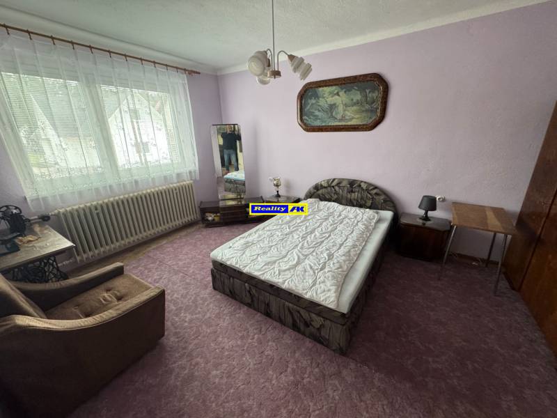 Schlafzimmer mit Bett, Sessel und Bild im Einfamilienhaus.