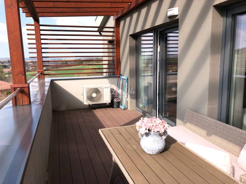 Die Terrasse einer 2-Zimmer-Wohnung mit Blick auf die Umgebung und Blumendekoration.