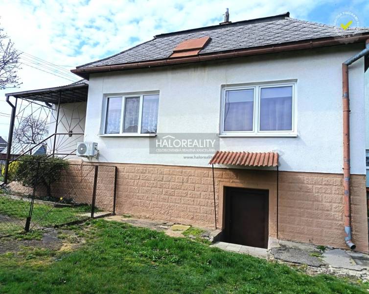 Ein Einfamilienhaus in Hráň mit einem Rasenhof, Fenstern und Eingangstüren.