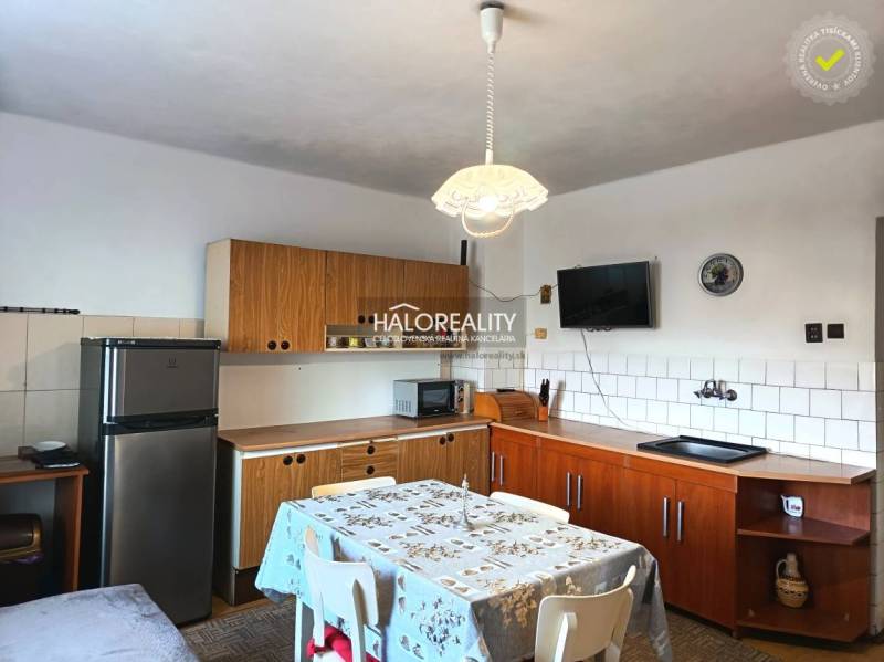 Eine Küche in einem Einfamilienhaus mit Holzkücheneinrichtung und Esstisch.