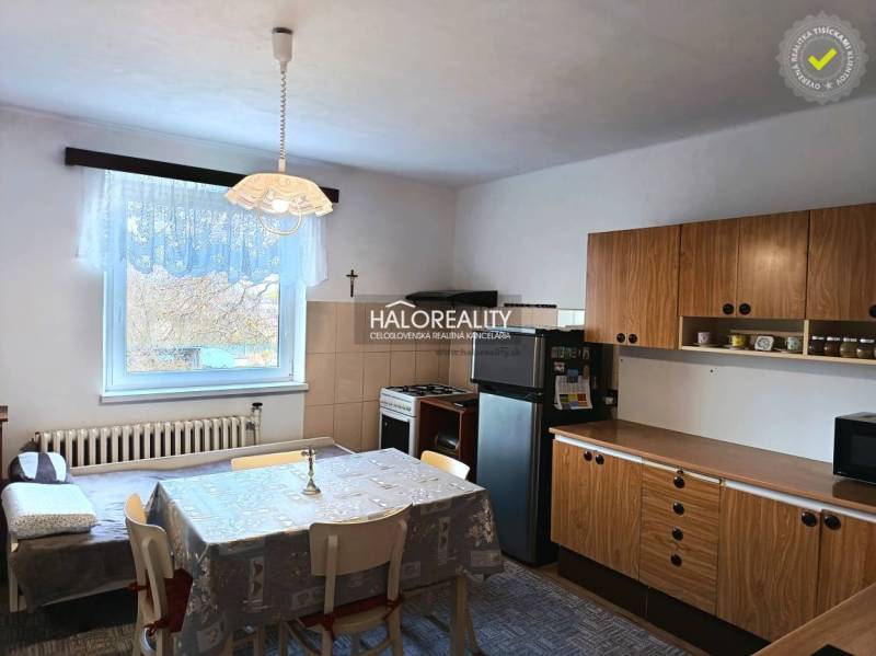 Küche in einem Einfamilienhaus mit Esstisch und Holzschränken.