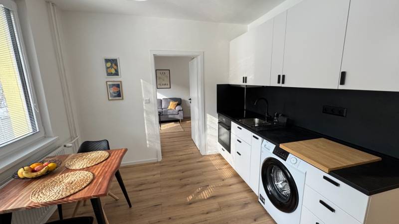 Küche in einer Einzimmerwohnung mit Ausstattung und Boden in Holzoptik.