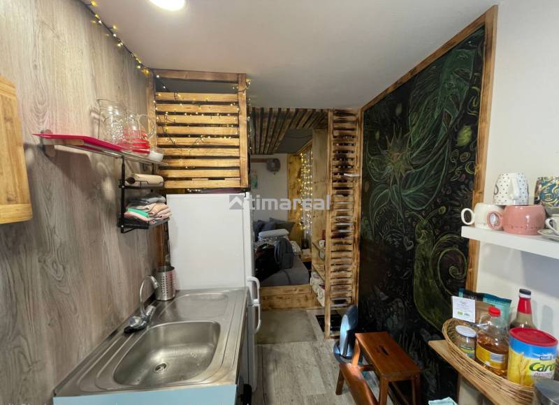 Küchenecke mit Holzdekorationen und Regalen, Boden mit Holzdekor.