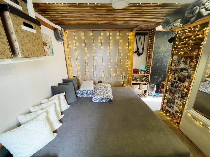 Interieur eines Einfamilienhauses mit Bett, Kissen und Lichtdekoration.