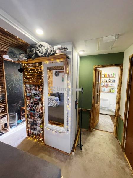 Innenraum eines Einfamilienhauses mit beleuchteten Dekorationen, Spiegel und Fotos an der Wand.