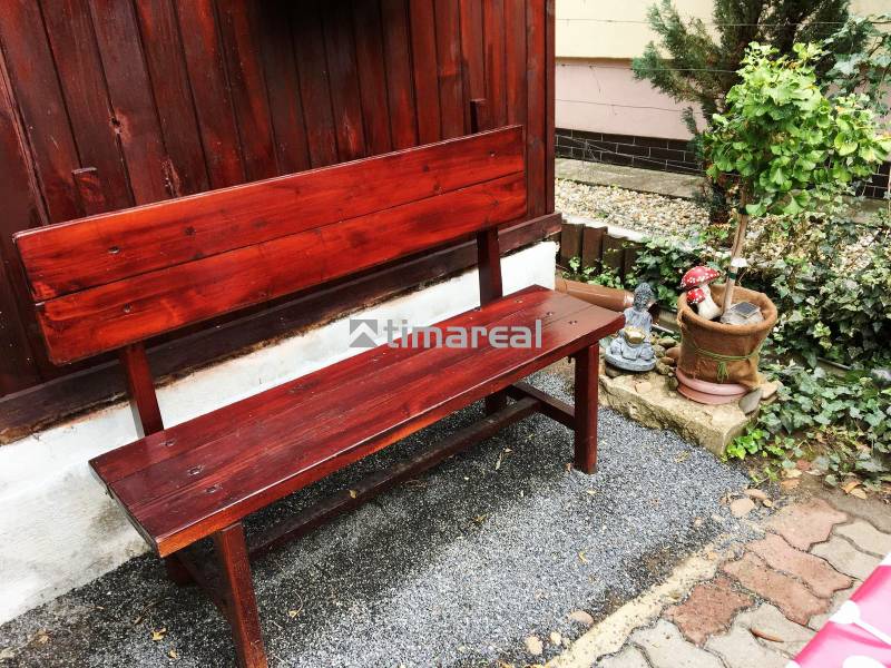Holzbank mit Pflanze und dekorativer Verzierung bei einem Einfamilienhaus in Bohdanovce nad Trnavou.