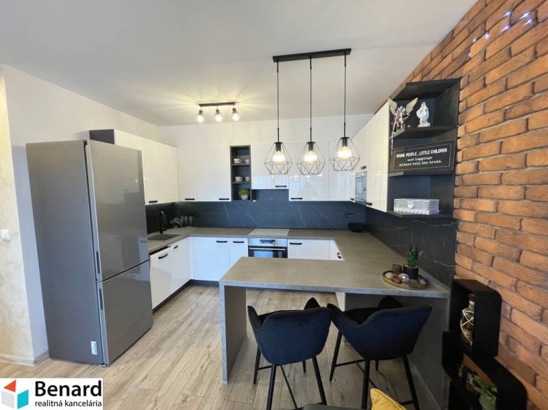 Küche in einer 2-Zimmer-Wohnung mit Holzboden und Backsteinverkleidung an der Wand.