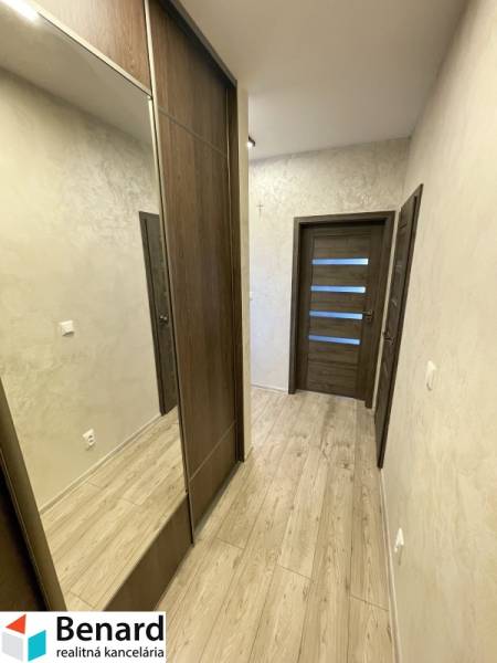 Flur mit Holzboden, Einbauschrank und Türen in einer 2-Zimmer-Wohnung.