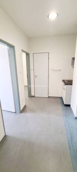 Innenräume von Büros mit Laminatboden und weißen Wänden, Küchenzeile in der Ecke.