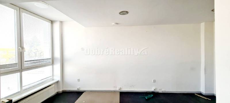Weiße Wände mit einem großen Fenster und einem Holzboden in einem Büro.