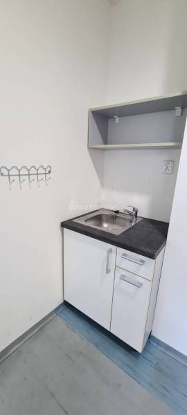 Büros mit Schrank, Spüle und Regal, Boden mit Holzdekor.