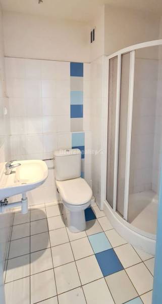 Badezimmer mit Toilette, Duschkabine und Waschbecken im Büro.