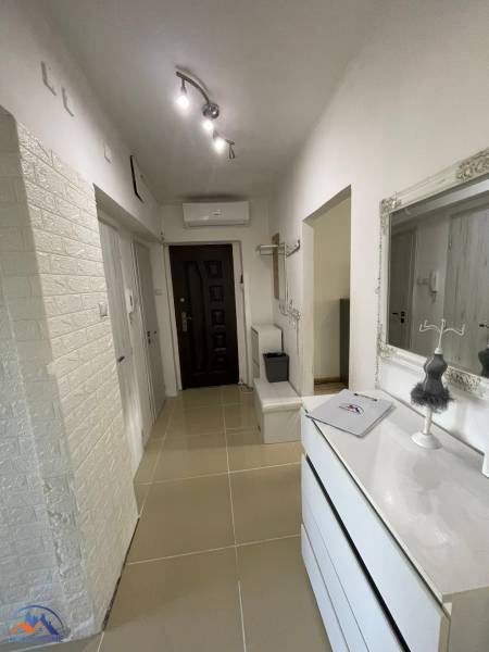 Eingangsflur einer 3-Zimmer-Wohnung mit weißen Möbeln und hellem Boden.