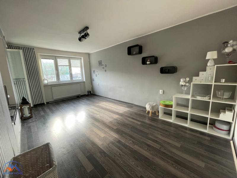 Wohnzimmer mit Holzboden, Dekorationen und Regalen in einer 3-Zimmer-Wohnung.