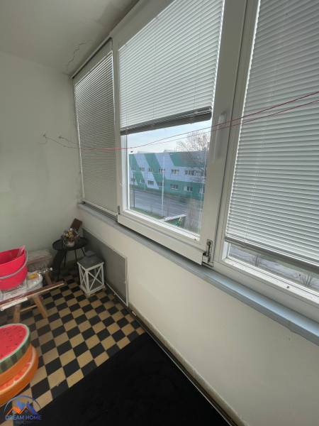 Ein verglaster Balkon mit Blick auf die Straße und einem Schachbrettboden in Hurbanovo.