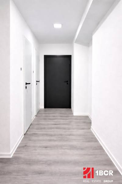 Ein Flur mit hellen Wänden und einem Boden in Holzoptik in einer 3-Zimmer-Wohnung.