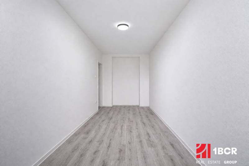 Ein enger Raum mit einem Boden in Holzoptik in einer 3-Zimmer-Wohnung.