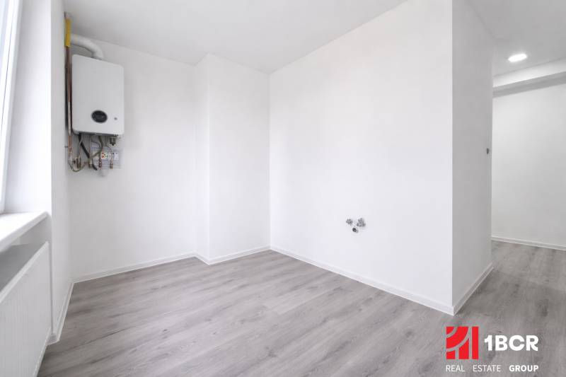 Ein Zimmer mit einem Kessel und einem Boden in Holzoptik in einer 3-Zimmer-Wohnung.