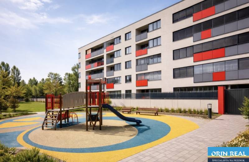 Malokrasňanská Straße in Bratislava - Rača mit einem Wohnhaus und einem Kinderspielplatz.