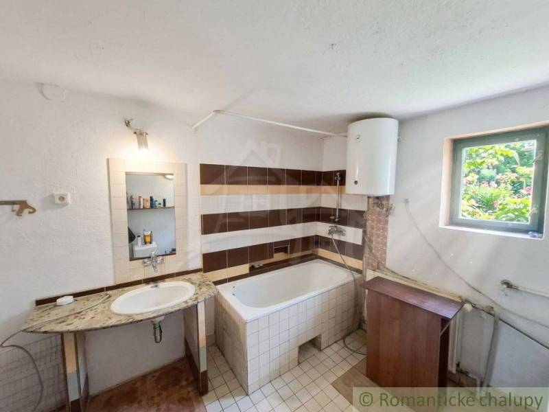 Badezimmer im Einfamilienhaus mit Waschbecken, Badewanne und Boiler.