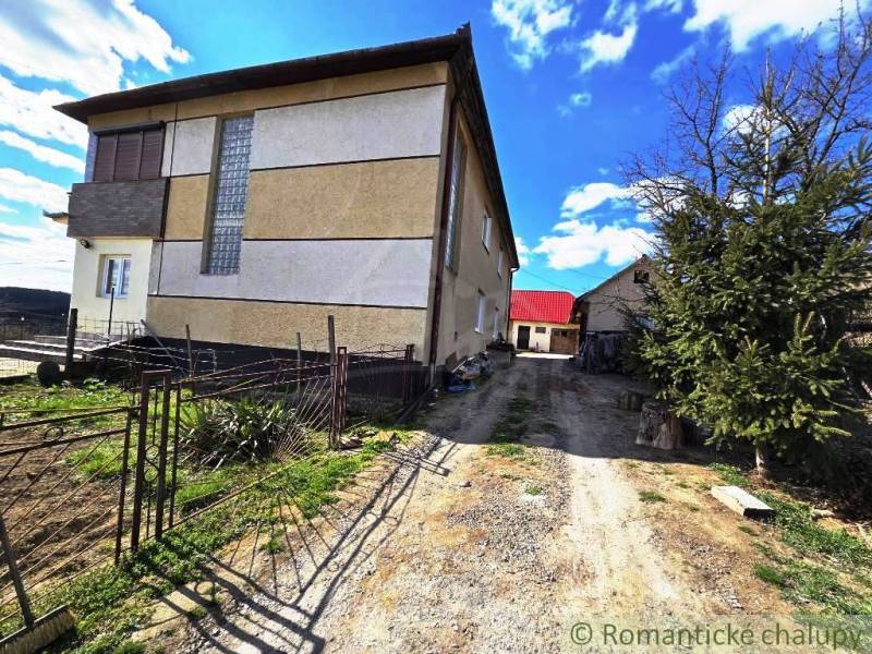 Ein Einfamilienhaus in Kiarov mit einem geräumigen Hof und Garten, daneben steht ein Nadelbaum.