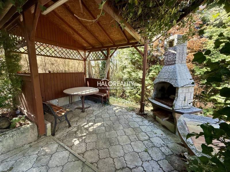 Pergola mit Tisch und Kamin in den Gärten von Rimavská Sobota.